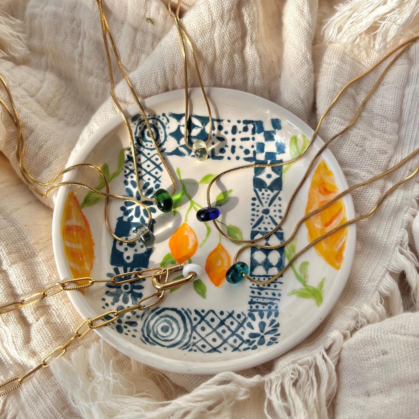 
                  
                    Jewelry displayed on a decorative plate with a floral pattern
                  
                