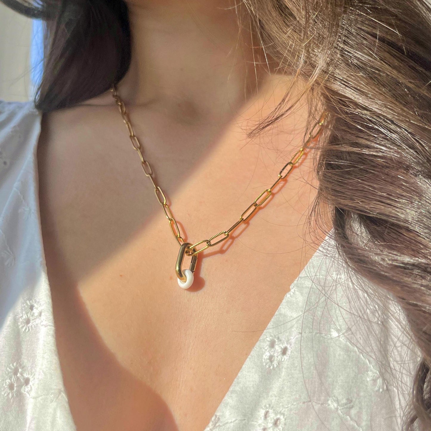 Gold chain necklace worn by a person with a blurred background